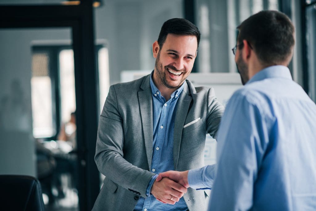 Two man shake hands over a new business deal.