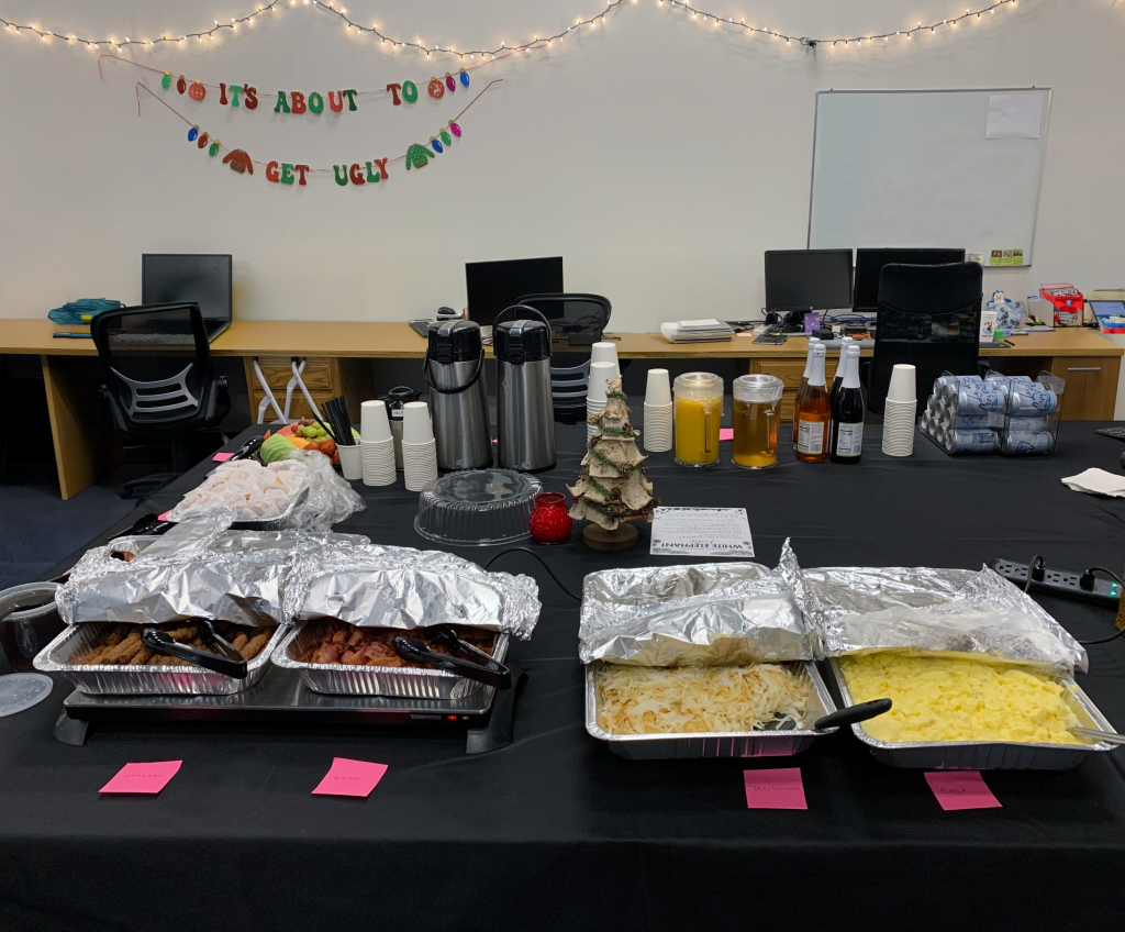 Holiday breakfast spread with eggs, hashbrowns, bacon, sausage, french toast, bagels, and an array of drinks.