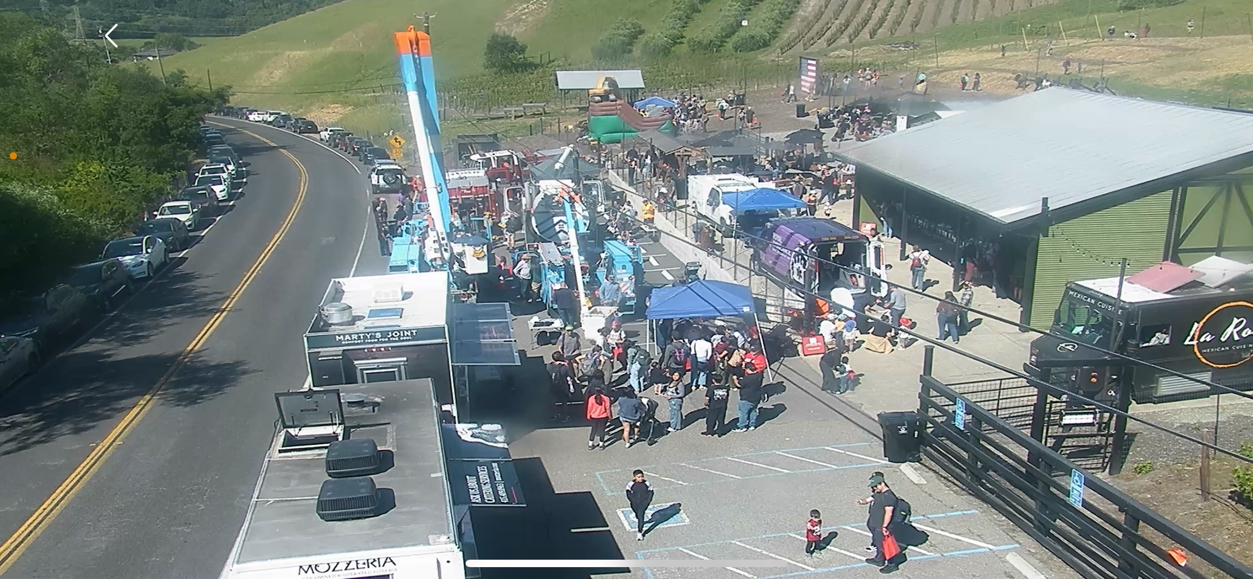 A top-down view of the Touch-A-Truck event, showcasing trucks, food trucks, and people enjoying the event.